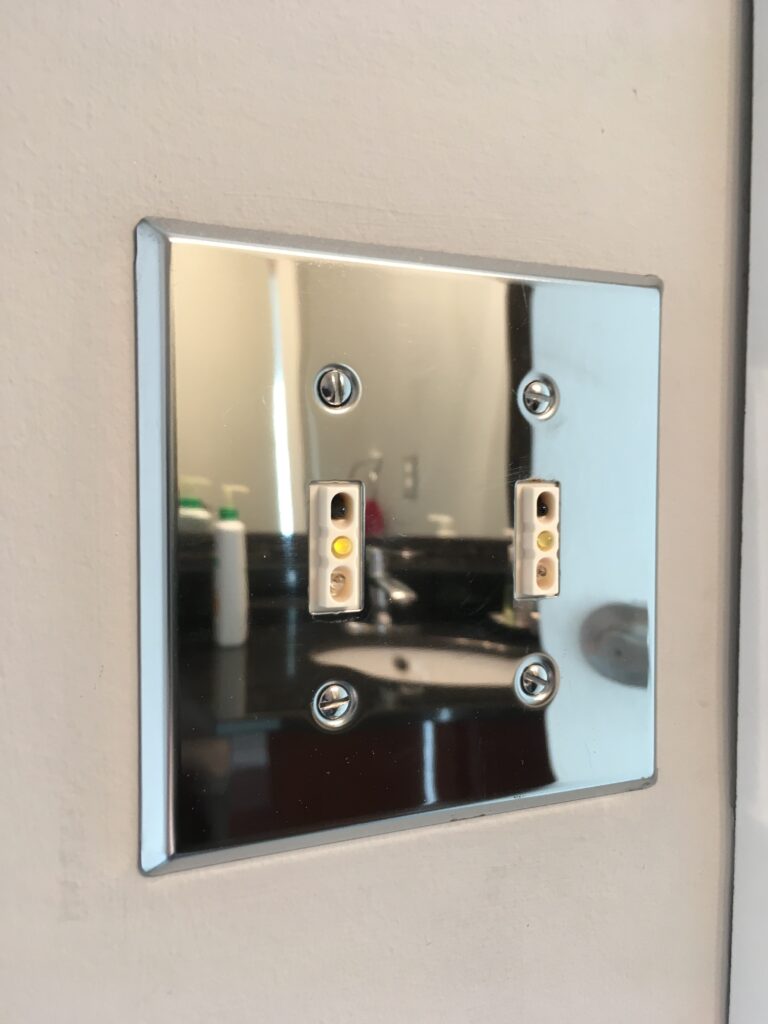 Bathroom sink reflection in chrome faceplate for 2 Touchless Light Switches