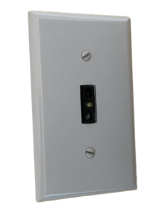 A black touchless switch mounted to a common switch faceplate